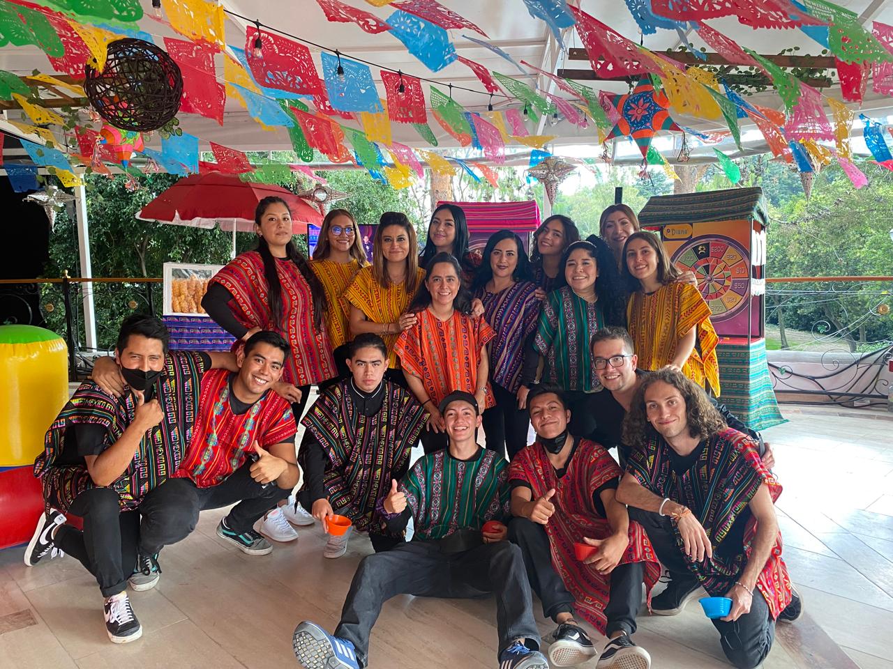 Equipo de animadores de Divertidísimo bajo el papel picado de una kermés